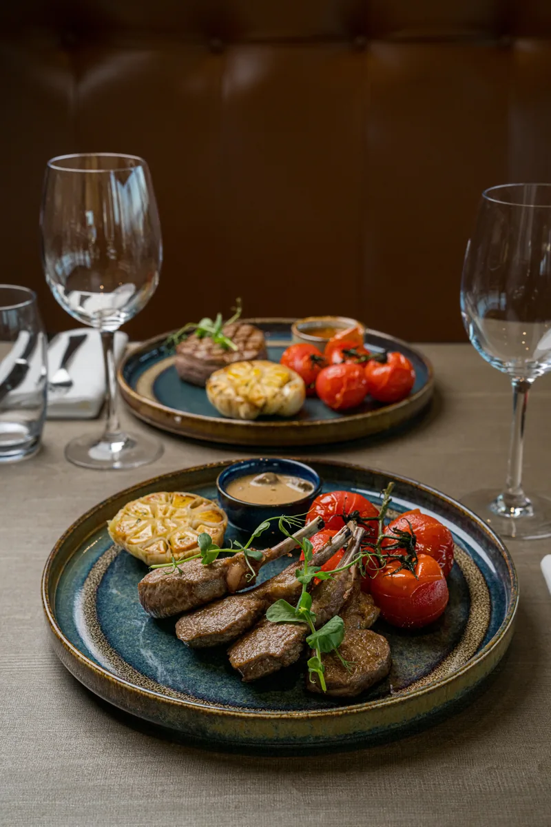 Deux assiettes dressées avec soin et des verres sur une table de restaurant