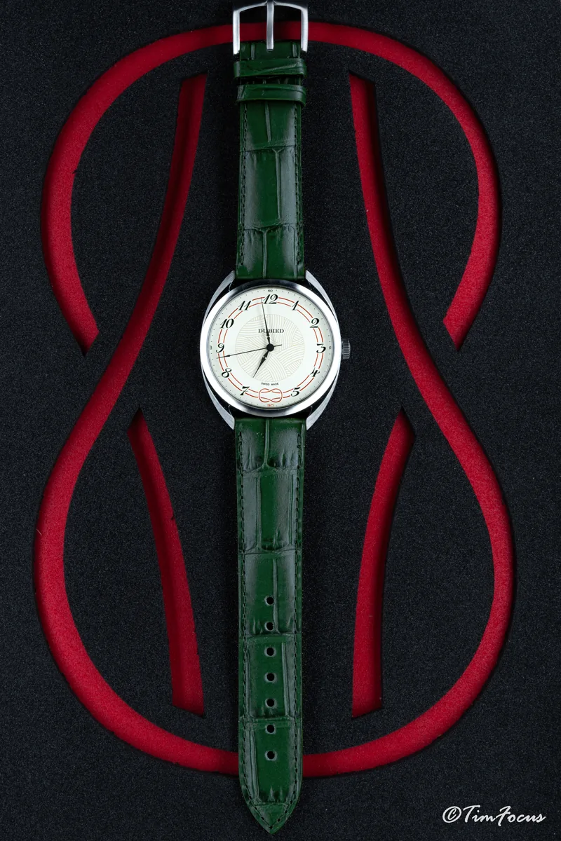 Montre au bracelet vert présentée sur un fond noir et rouge