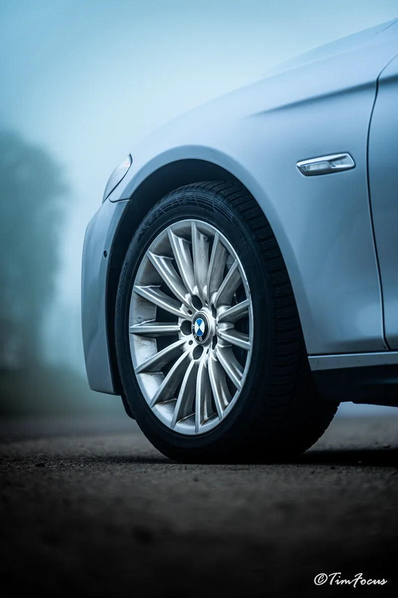 Détail d’une roue et de la carrosserie d’une voiture bleue
